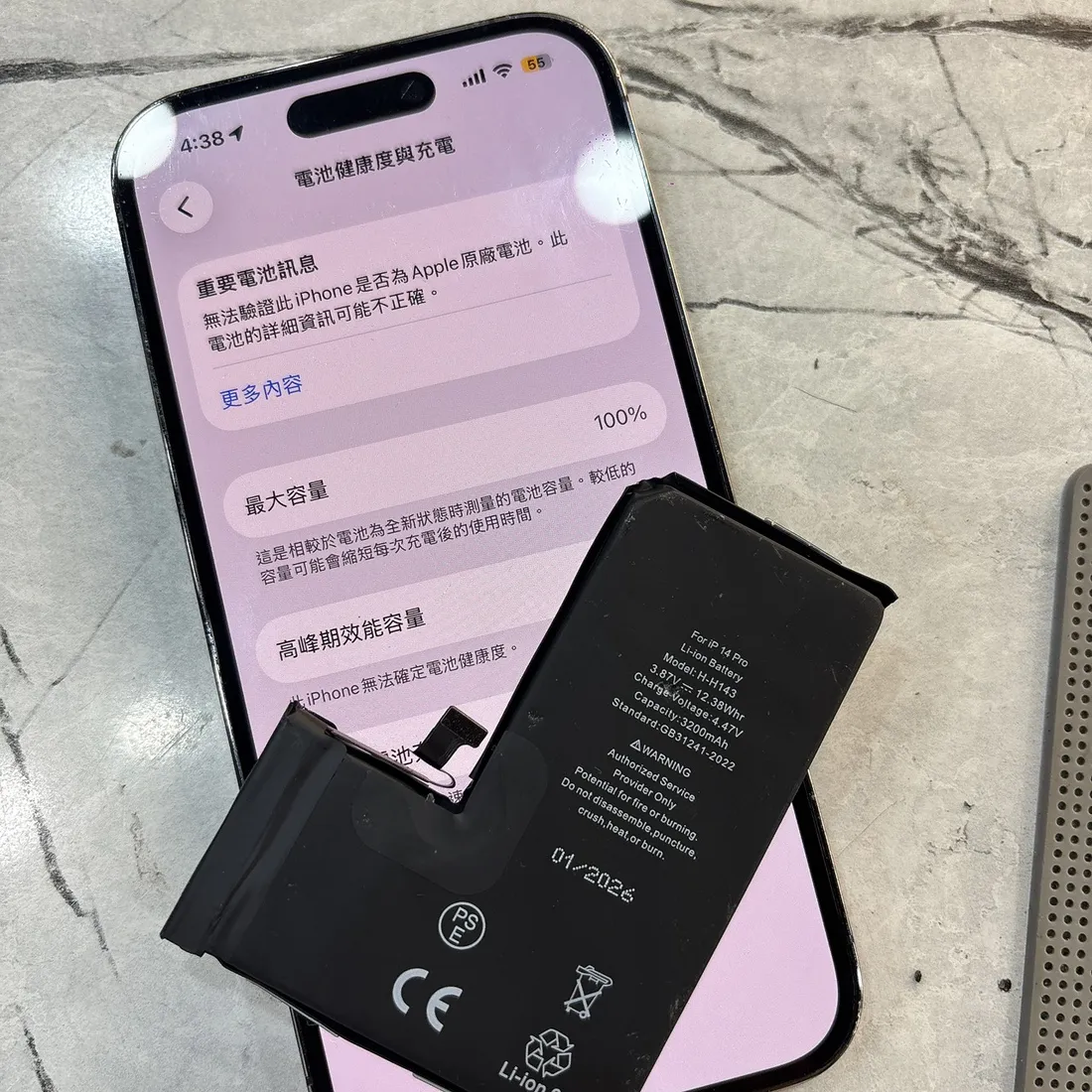 台南 iPhone 14 Pro 電池膨脹更換,換上新電池後最大容量 100%,上方為換下的膨脹電池